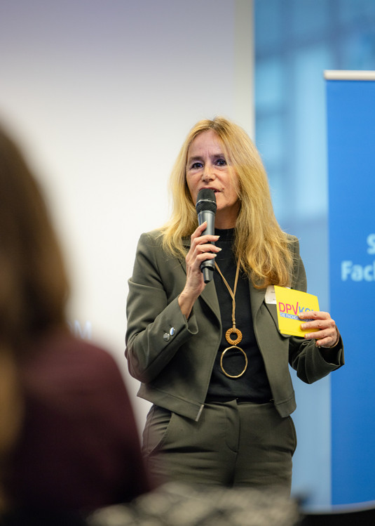 Christina Dahlhaus spricht mit Mikrofon zu den Teilnehmenden